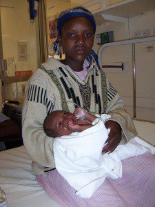 Local African woman holding her infant born with cleft lip and palate.